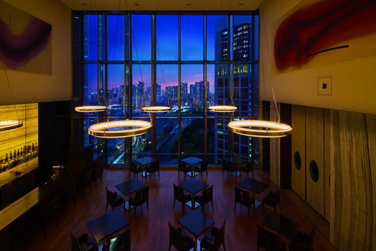 高い天井と窓からの夜景が印象的なTHE BARの店内