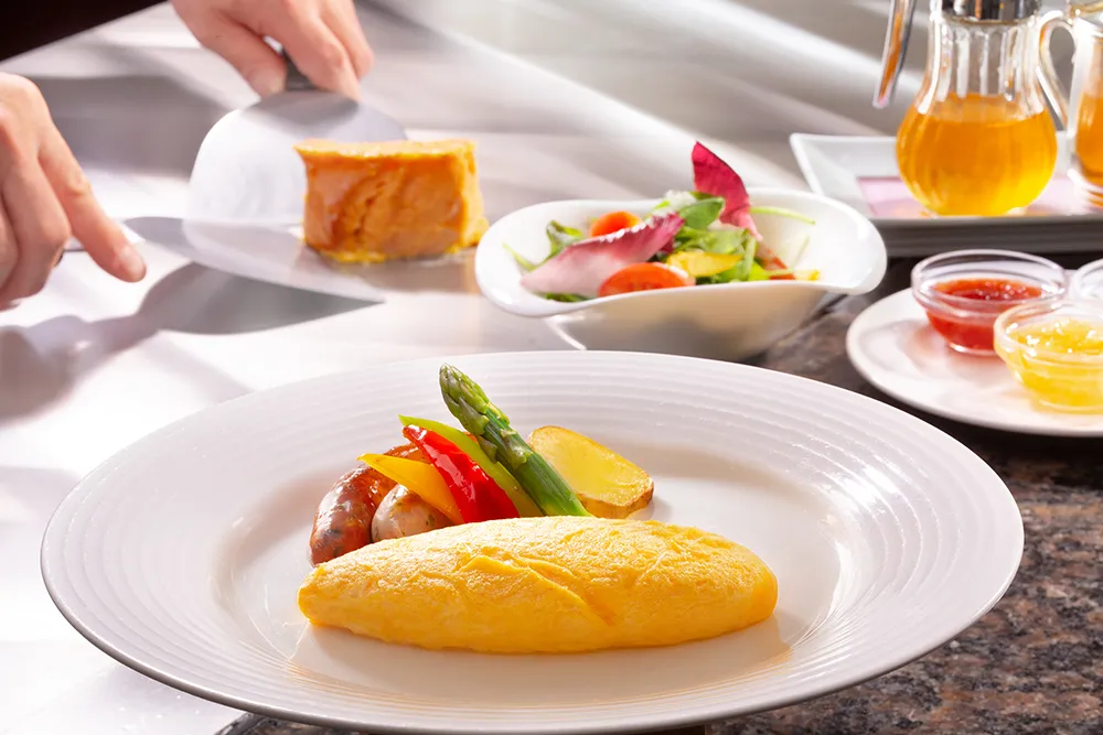 鉄板の上で調理されるオムレツと付け合わせの野菜