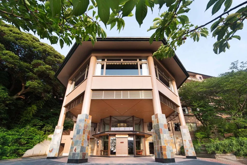 木々に囲まれた吉祥CARENの重厚な建物外観